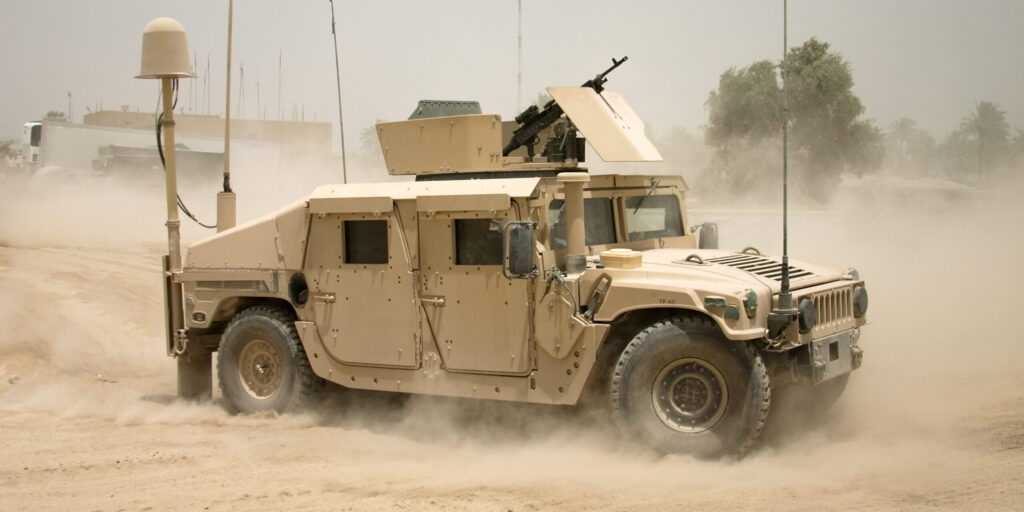 View of armored military vehicle with dust surrounding it