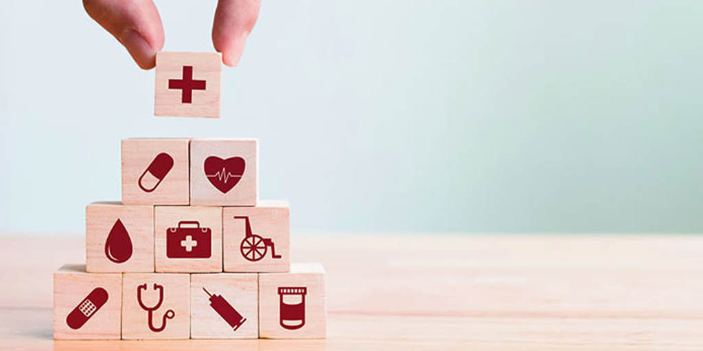 A pyramid of tan building blocks with red medical insignia on it