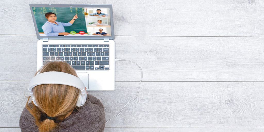 Girl wearing headphones watching class on laptop