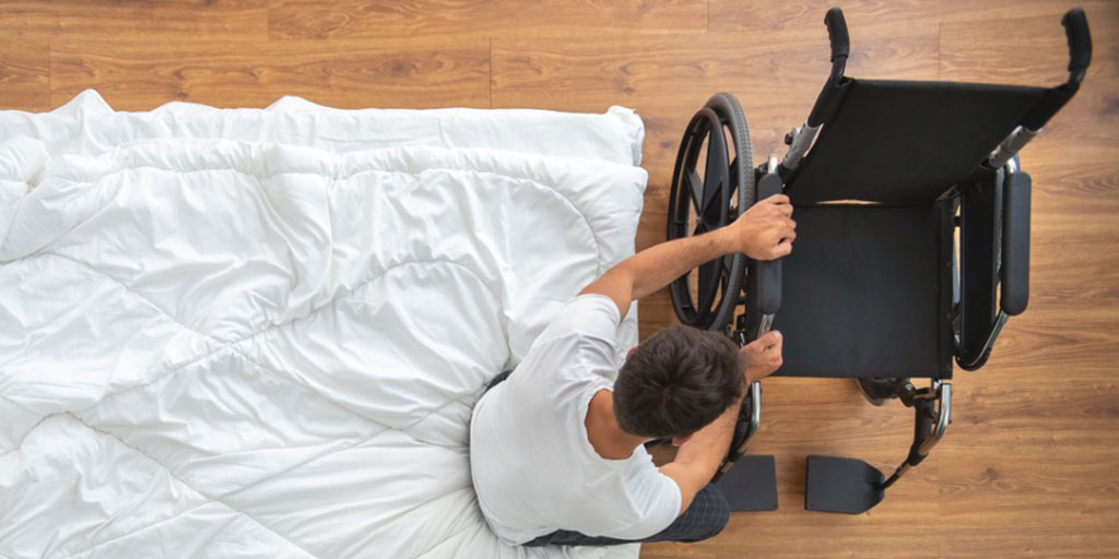 the-disabled-man-sitting-on-the-bed-view-from-above-picture-id1077172566-1