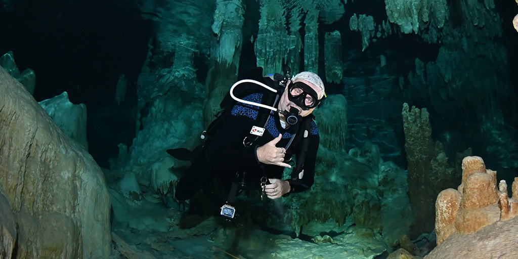 man scuba diving in an underwater cave