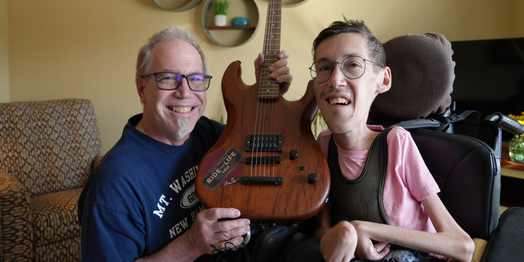 Jon & Shane Burcaw with the hand-made, autographed guitar up for auction at this year’s Ride for Life event
