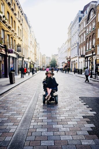 Jax Cowles in power wheelchair on city street in London