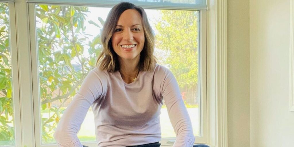 Amy Shinneman seated on the floor in her home exercise room.