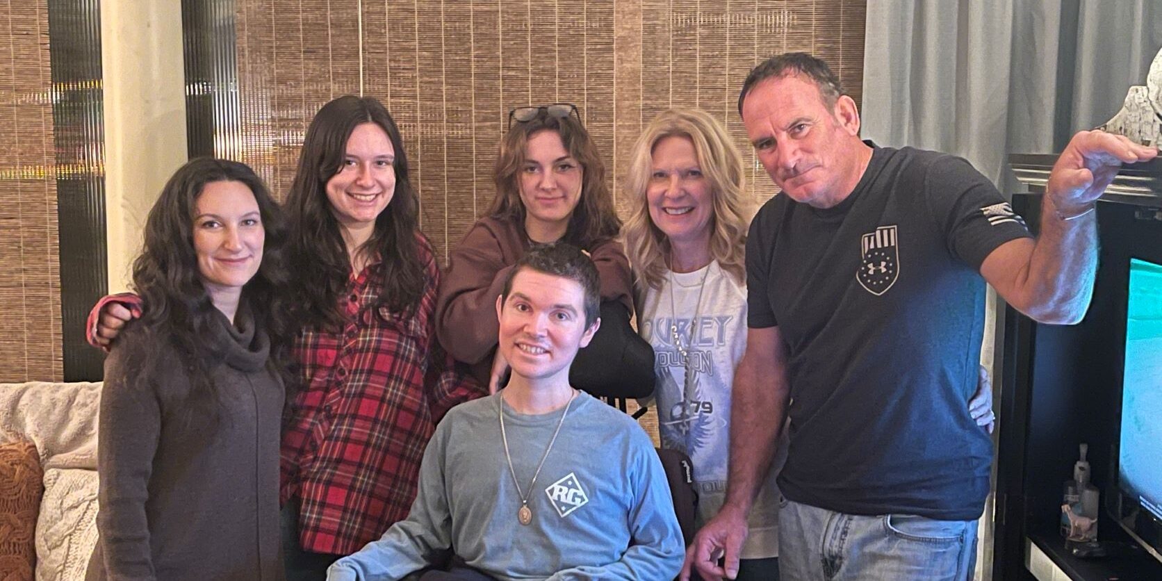 Beckley sits in his wheelchair surrounded by his three sisters, mother, and father.