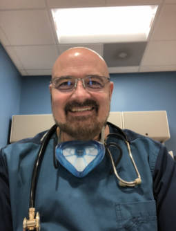 Respiratory therapist Rick Gonzalez in blue scrubs with a stethoscope around his neck.