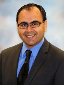Headshot of Dr. Amit Sachdev, a man with light brown skin and short black hair, wearing glasses