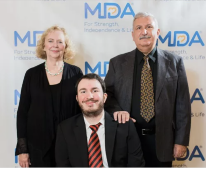 Chris Anselmo and his parents pose in front of an MDA logo photo backdrop