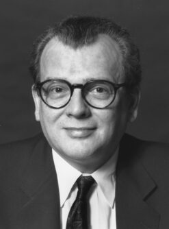 Black and white headshot of Victor Wright wearing glasses and a suit coat and tie.