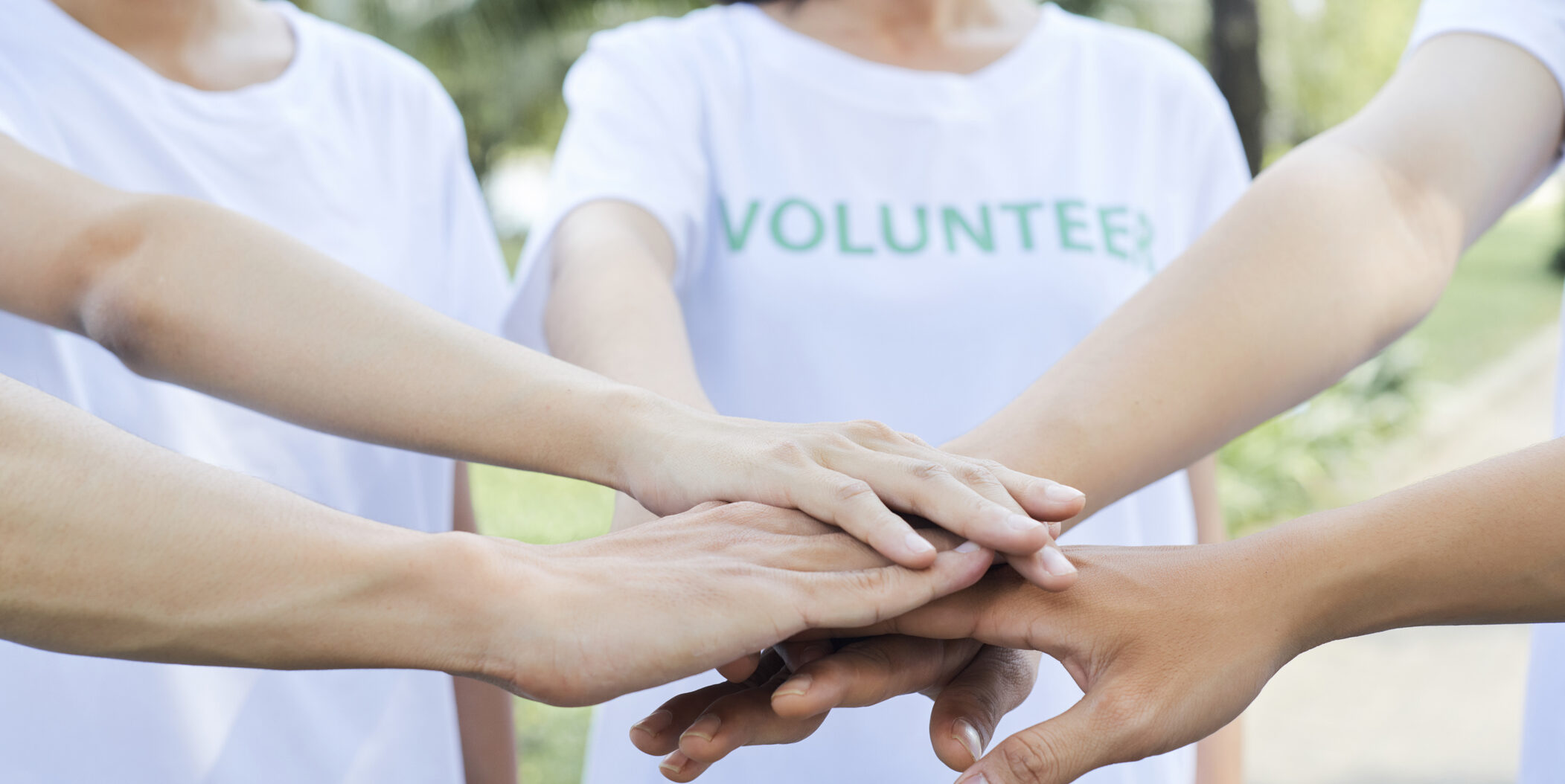 Close-up image of volunteers stacking hands
