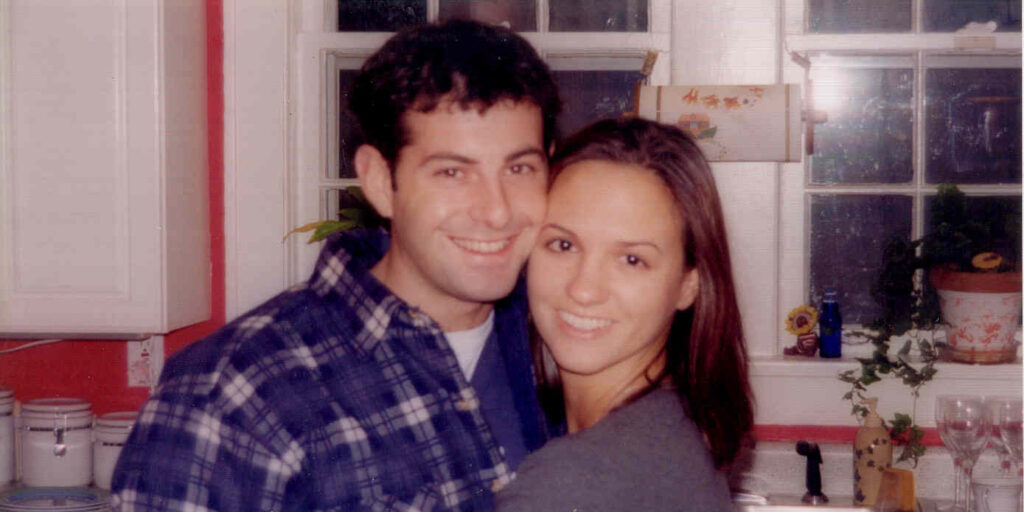 Jamie and Amy Shinneman hug and smile in their kitchen.