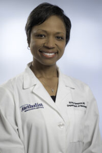 Headshot of Dr. Ericka Greene, a Black woman with short, black hair, wearing a white lab coat.
