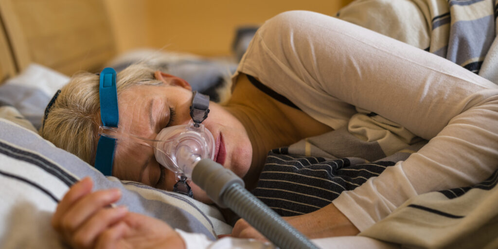 woman using cpap machine to stop choking and snoring from obstructive sleep apnea