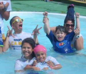 A group of campers and volunteers in a swimming pool at MDA Summer Camp