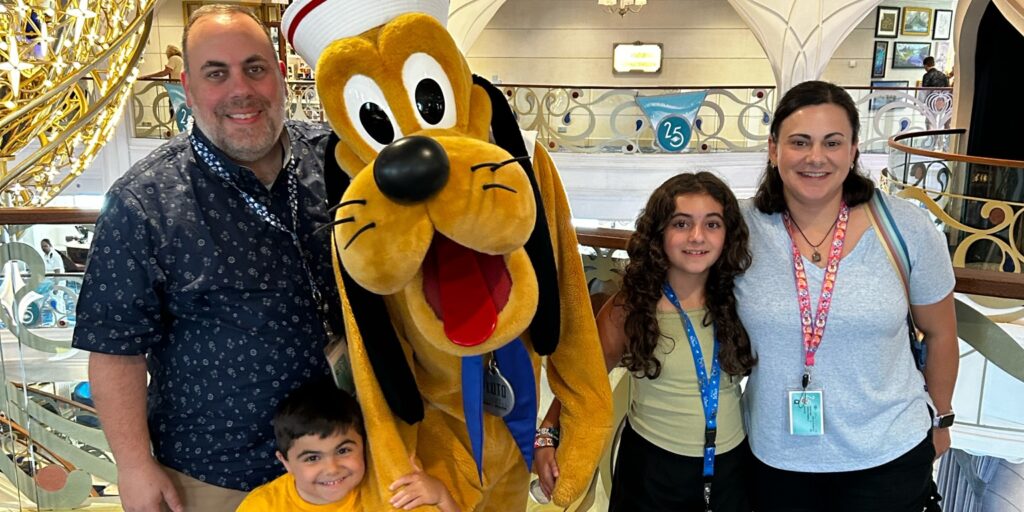 A family poses with Disney's Pluto