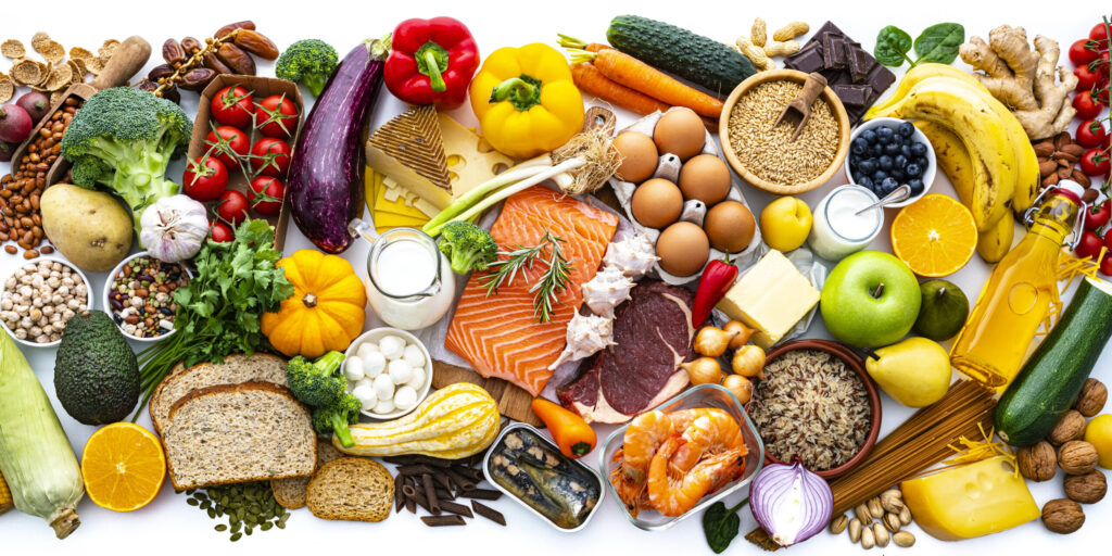 Overhead view of a large group of all sort of food for a well balanced and healthy diet