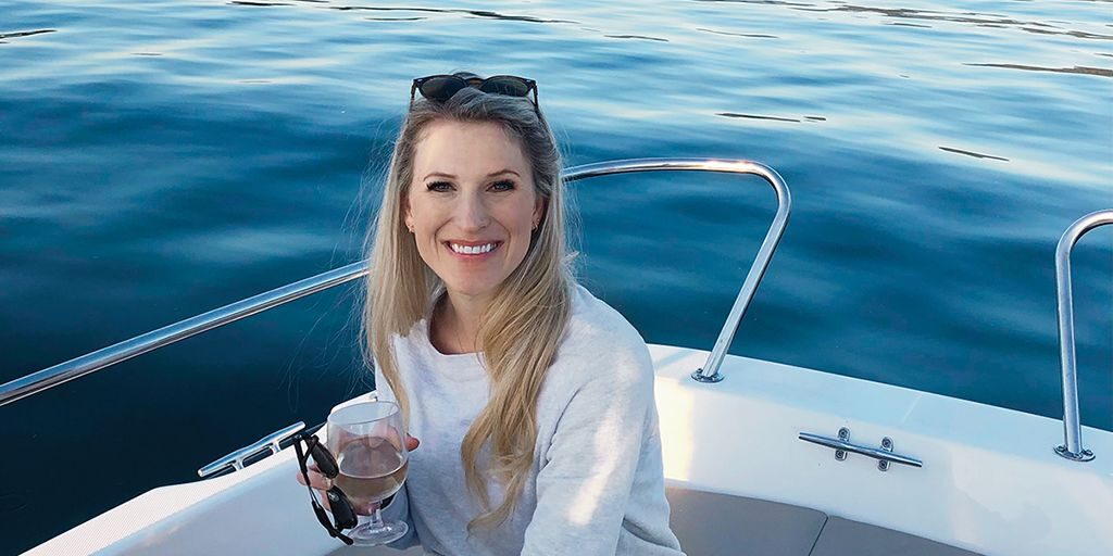 Emily Blume sits on a boat holding a wineglass.