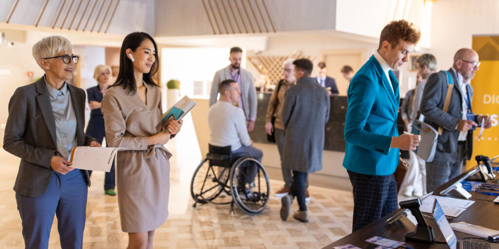 A group of conference participants registering in a hotel lobby