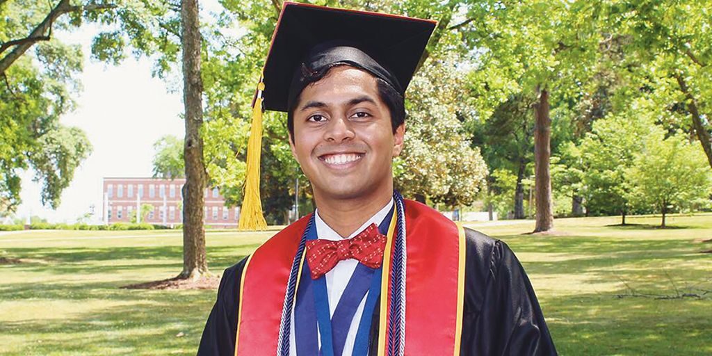 Abhiram Srivatsa, DO, a doctor who lives with Emery-Dreifuss muscular dystrophy, poses in his graduation cap and gown.