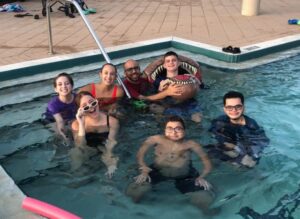 Juliette (far left with purple shirt), Kat (Right of Juliette with red bathing suit), Rachel (in front of Juliette with white sunglasses), Jesse (floating the furthest forward), Gio (far right), Gavin (in dino floatie), and Red (holding Gavin)