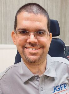 Close-up of Jonathan Greeson, a man with close-cropped brown hair and beard, light skin, and wire-rimmed glasses.