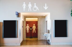 A public restroom entrance hallway with large male and female figures on the wall to indicate which direction to go.