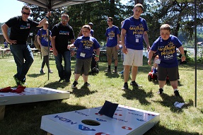 Campers and volunteers from local Albertsons companies division play beanbag toss at MDA Summer Camp. 