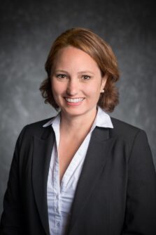 Headshot of a white woman with short brown hair in a suit coat