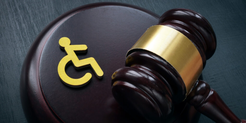 Disabled person sign and gavel. Accessibility law concept.