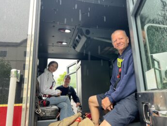 Lilly and a firefighter pose in a firetruck