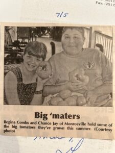 Newspaper clipping showing Regina and Chance holding tomatoes they grew in the summer with the caption “Big ‘maters.”