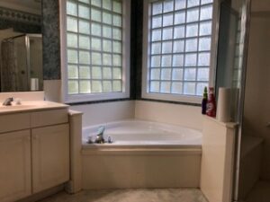 Large bathtub in the corner of a bathroom.