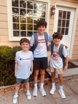 Three young boys pose outside together