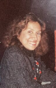 Closeup of Eileen Carlo, a woman with light sking and curly brown shoulder-length hair.