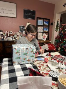 Ally opens cards and gift during the holiday season.