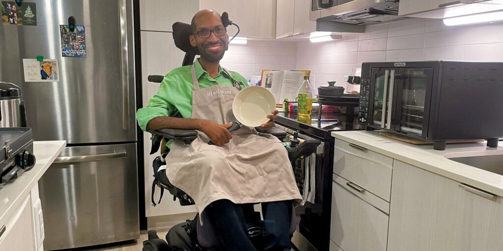 Ira Walker sits in a wheelchair and holds a lightweight cooking skillet.