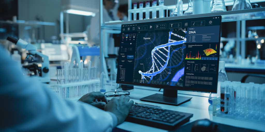 Medical Research Scientist Working on Desktop Computer with Gene Analysis Software in Modern Science Research Laboratory. Lab Engineers in White Coats Conduct Experiments in the Background.