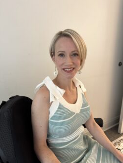 A woman with short blonde hair wearing a green and white dress