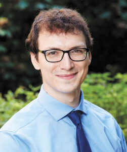 Headshot of researcher Francis Rossignol, a man with short, curly brown hair, light skin, and black-rimmed glasses.