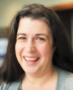 Headshot of Julie Christensen, a woman with long, straight brown hair and light skin.