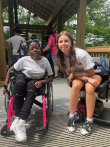 Courtney B. my scooter with her friend at MDA camp 2024 about to do the zip line