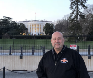 A fire fighter poses in front of the White House in Washington D.C.