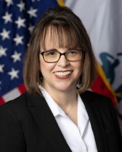 Headshot of Heather Ansley with an American flag background.