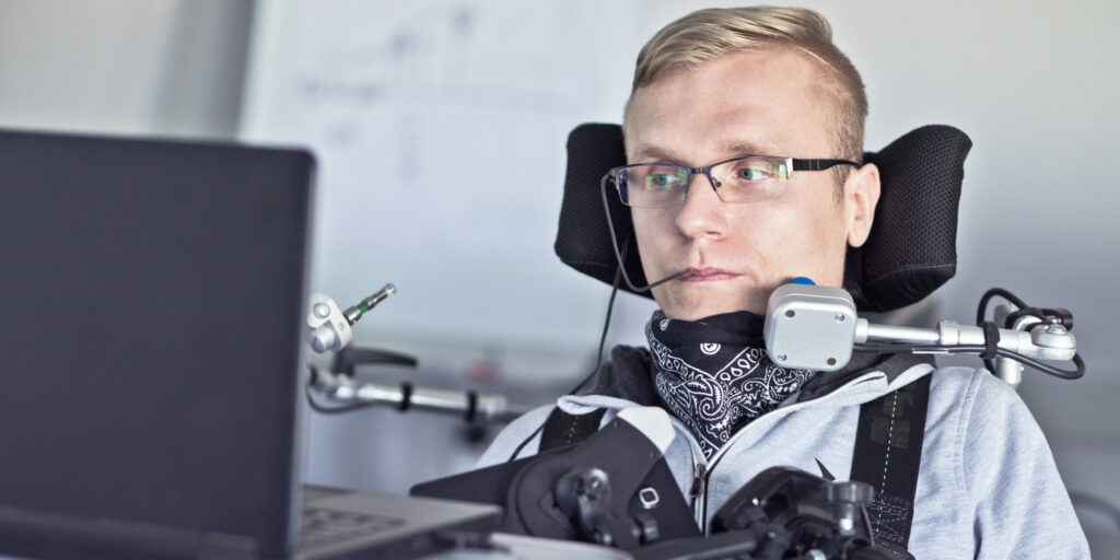 Disabled student in class room working with laptop.