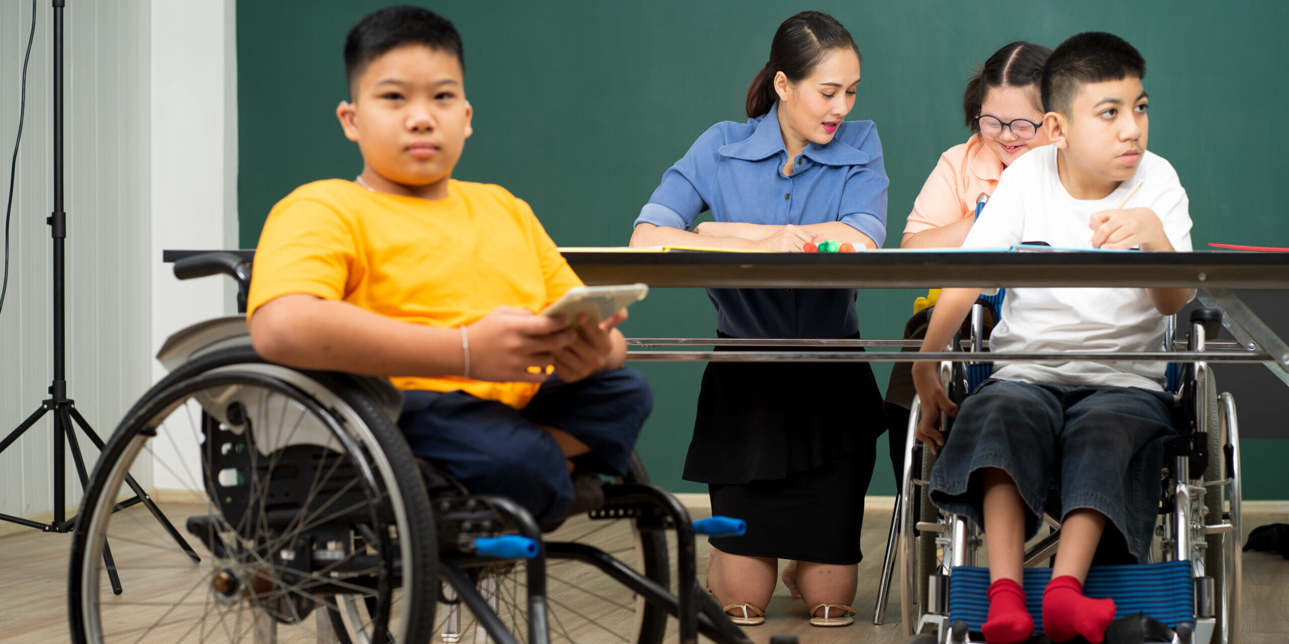 Asian kids with disability in special school classroom with Autism child and attractive teacher.