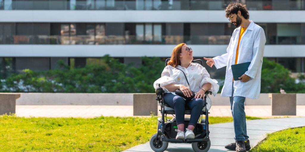 Occupational therapist and a woman in a power wheelchair talk outside