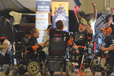 A group of power hockey players celebrate victory
