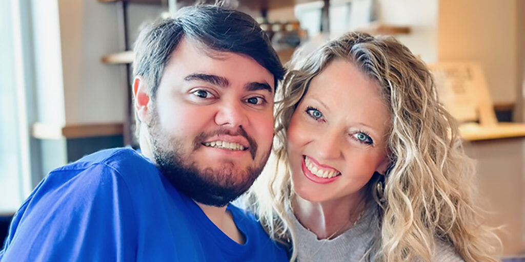 Closeup of Christie West and her 28-year-old son, Zach, smiling at the camera.