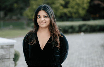 Headshot of Sonali, a woman with dark brown hair wearing a black dress