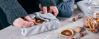 Wrapped gift in fabric with dry orange, cinnamon sticks. 